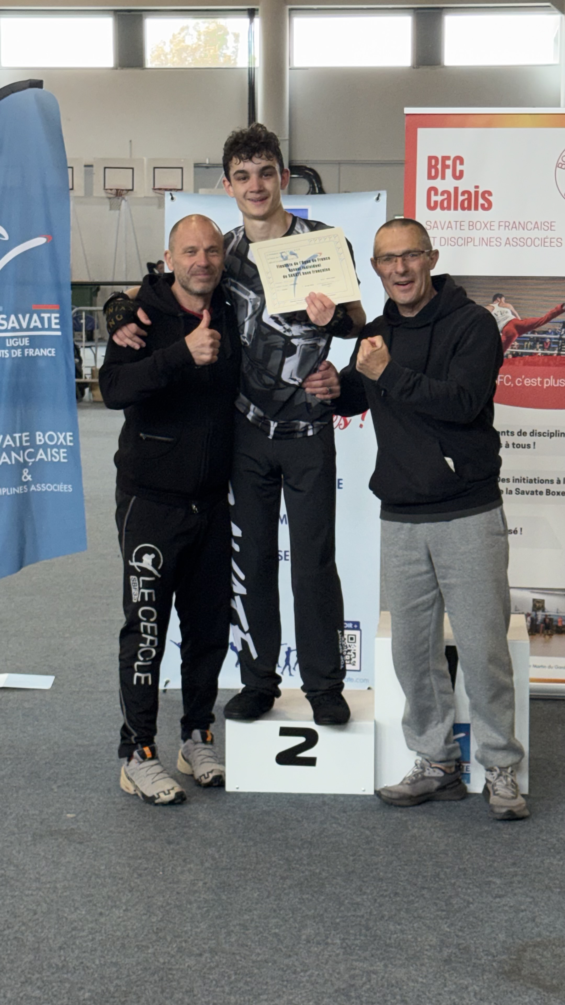 Boxeur du Cercle entouré de ses entraîneurs sur le podium